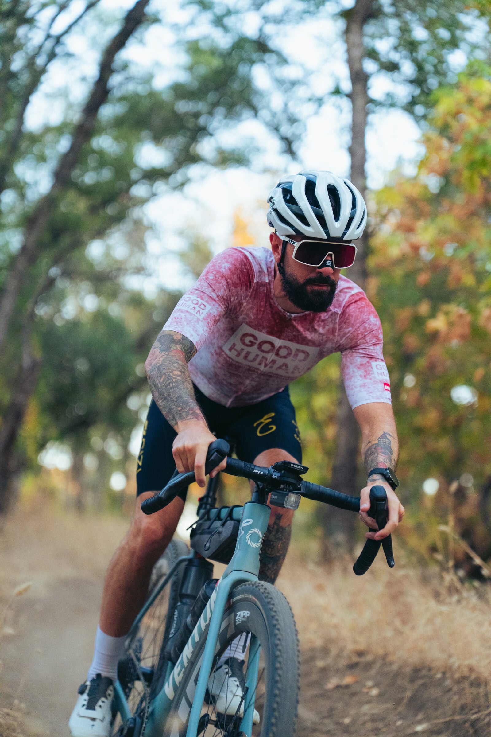Enjoy rider in club kit on a gravel trail.